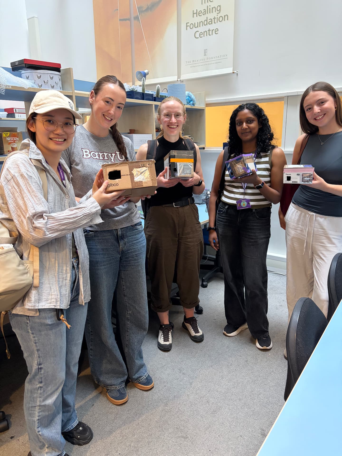 Lab members holding hand-made cardboard pinhole eclipse viewers